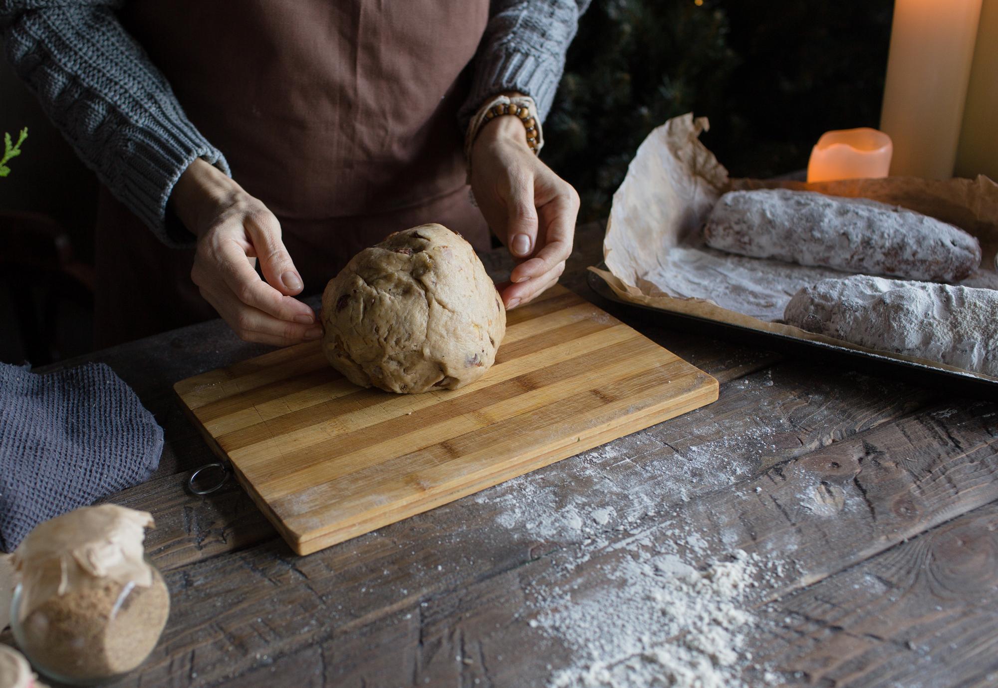 Close-up of hands kneading dough on a floured board