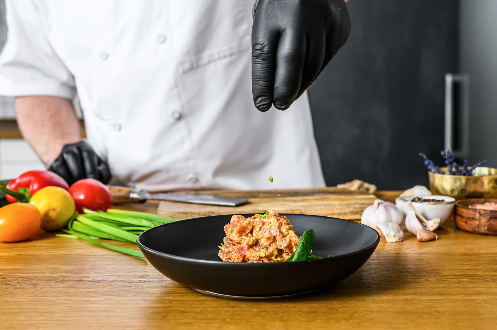 Instructor plating a composed dish in a home kitchen